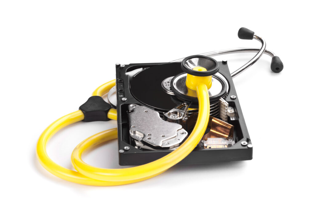Un disque dur ouvert avec un stéthoscope jaune placé dessus, symbolisant le diagnostic ou la récupération de données.